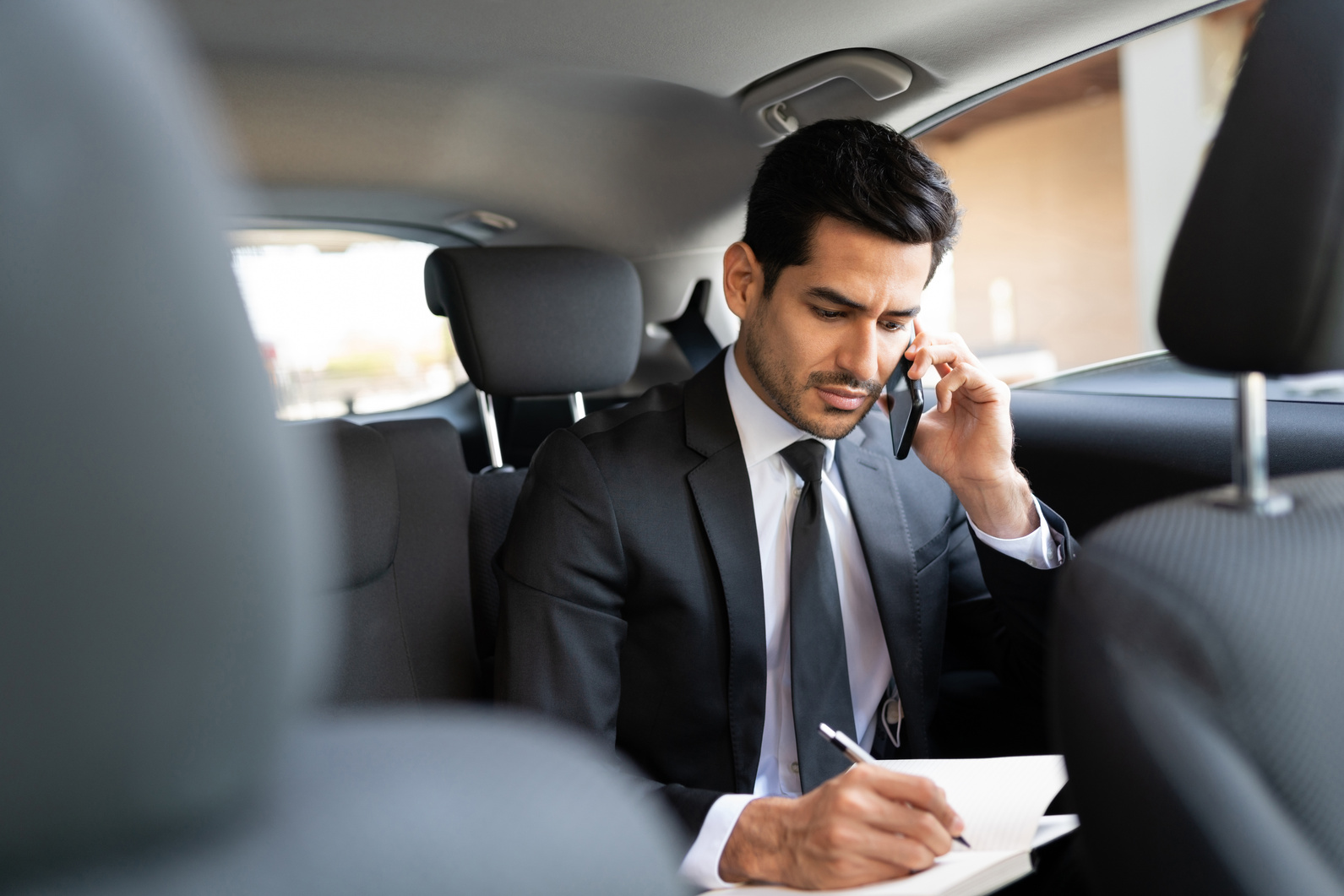 Business Executive Talking On Mobile Phone In Car
