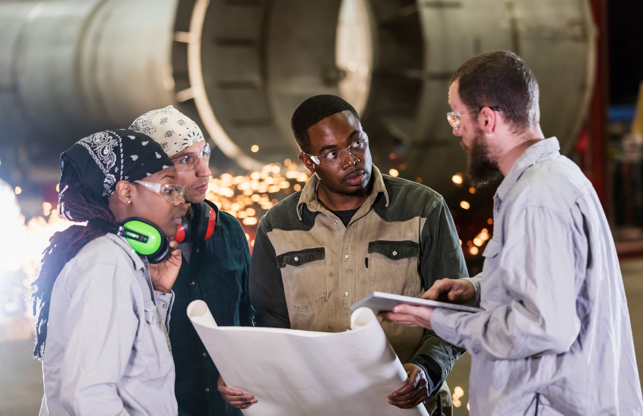 Industrial team reviewing plans in a fabrication facility