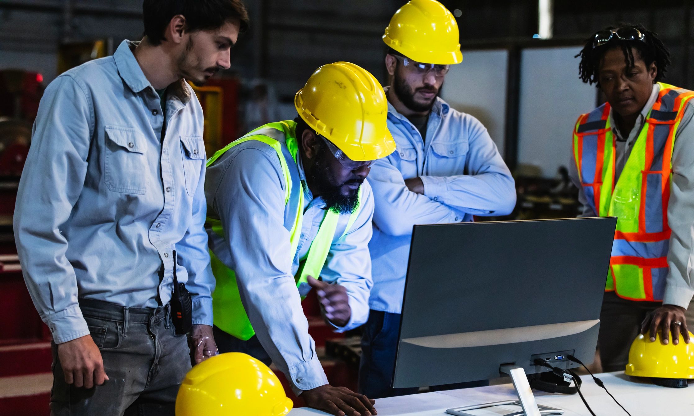 Factory team reviewing operations on a monitor